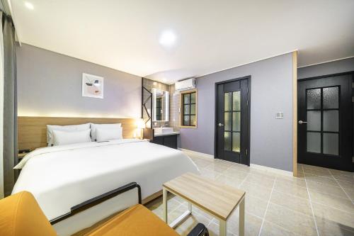 慶州市にあるBrown Dot Hotel Angangのベッドルーム(大きな白いベッド1台、テーブル付)