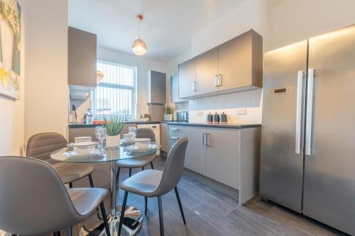a kitchen with a table and chairs and a refrigerator at Richmond Retreat - Luxurious and comfortable spacious 2 floor apartment in Manchester