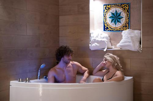 un homme et une femme assis dans une baignoire dans l'établissement Al Console Depandance con jacuzzi per coppia, à Monopoli