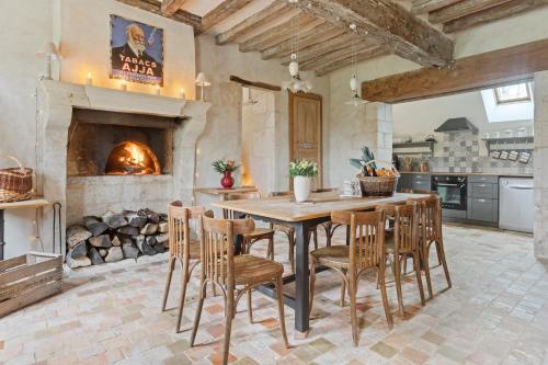 une cuisine avec une table et des chaises ainsi qu'une cheminée dans l'établissement Gîte de charme en rez de jardin, à Berdʼhuis