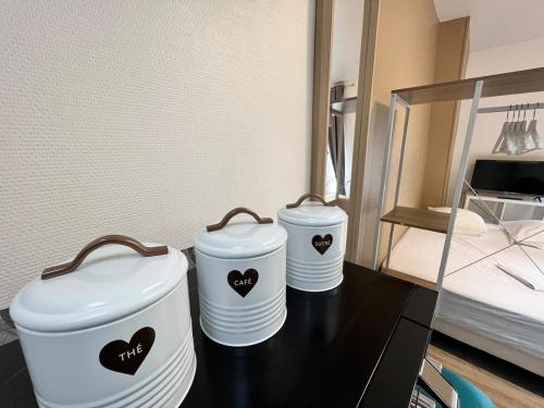 zwei weiße Behälter mit Herzen auf dem Tisch in der Unterkunft Studio SN9 - Centre-Ville Meaux - Proche Disneyland in Meaux