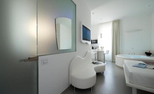 a white bathroom with a white chair and a tub at Gatto Bianco Mia Aparthotel in Milan