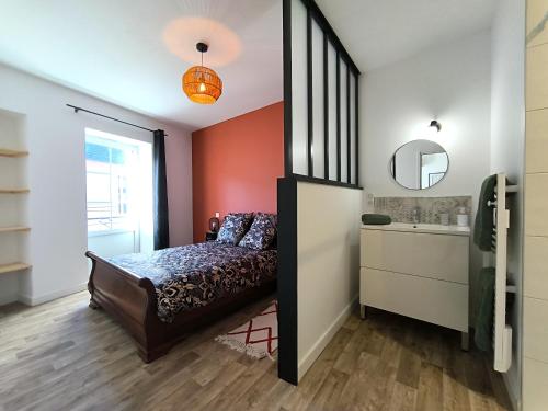 un dormitorio con una cama y un espejo en Le Talia - Terrasse, en Auch