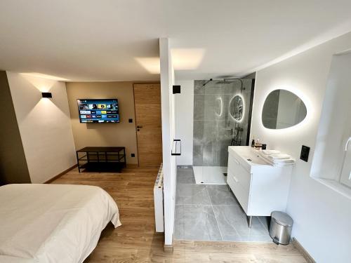 une salle de bain avec un lit, une douche et un lavabo dans l'établissement L'ancienne Étude - Superbe vue - Piscine chauffée, à Buis-les-Baronnies