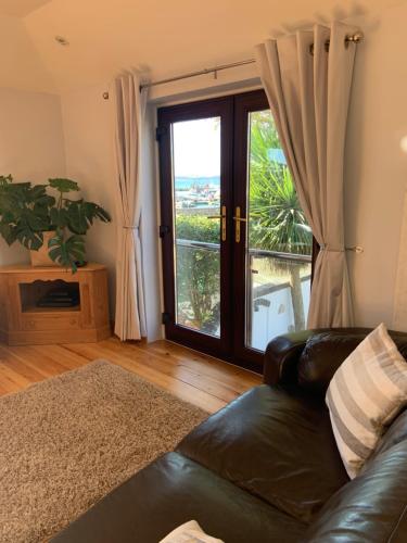 a living room with a leather couch and a window at Sea Breeze in Poole