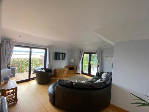 a living room with a black couch and a table at Sea Breeze in Poole