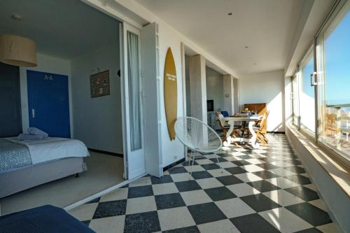 - une chambre avec un lit et un sol en damier dans l'établissement Ô sable fin - Front de mer, à Canet