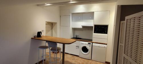 une cuisine avec une table et deux tabourets de bar dans l'établissement Studio indépendant contre la Cathedrale, au Puy-en-Velay