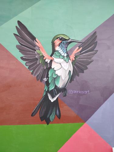 a painting of a humming bird in flight at Hostal mil colores in Guacamayas