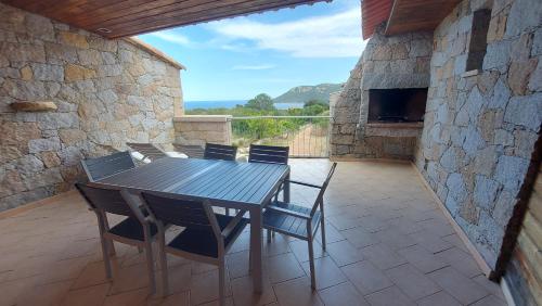 une table et des chaises en bois sur une terrasse dans l'établissement Résidence Les Pavillons du Belvédère, à Porto-Vecchio