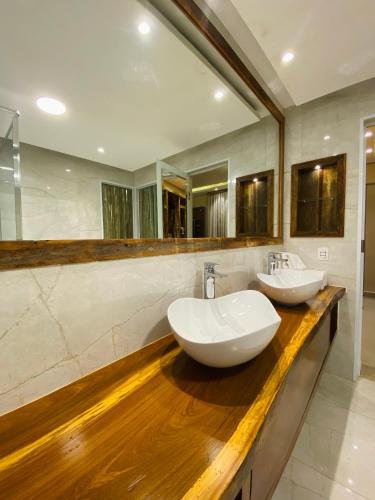 a bathroom with two sinks on a wooden counter at Meu Hotel Boituva in Boituva
