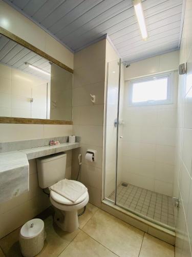 a bathroom with a toilet and a glass shower at Meu Hotel Boituva in Boituva