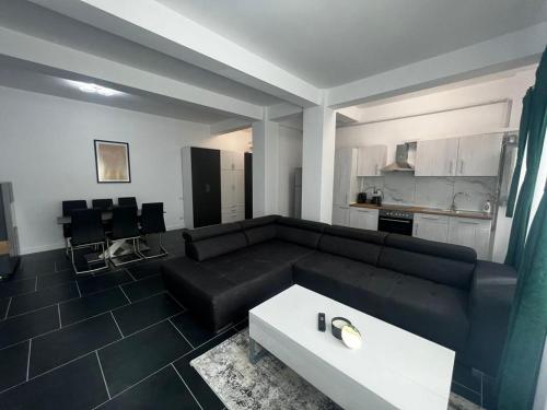 a living room with a black couch and a white table at Luxury Cozy Apartments Suceava in Suceava
