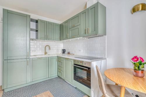 une cuisine avec des placards verts et une table dans l'établissement Apartment in Paris 17th District, à Paris