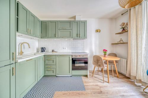 une cuisine avec des placards verts et une table en bois dans l'établissement Apartment in Paris 17th District, à Paris