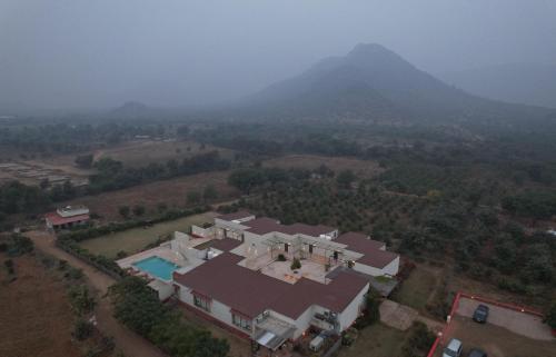 an aerial view of a house with mountains in the background at Guldaar Sariska - A luxury Forest Resort in Tehla