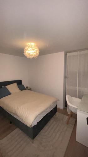 une chambre avec un lit et un lustre dans l'établissement Maison cozy proche centre ville, à Orvault