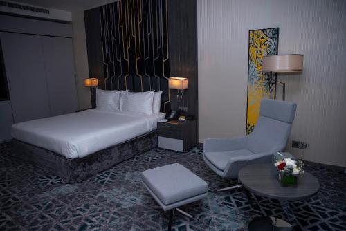 a hotel room with a bed and a chair at Executives Hotel - KAFD in Riyadh
