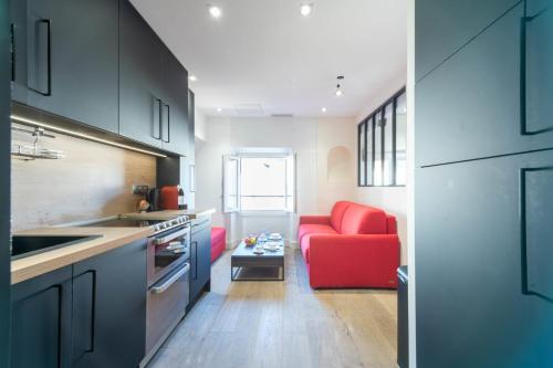 une cuisine avec un canapé rouge et un fauteuil rouge dans l'établissement 1-Br Apartment with Air Conditioning Near La Croisette, à Cannes