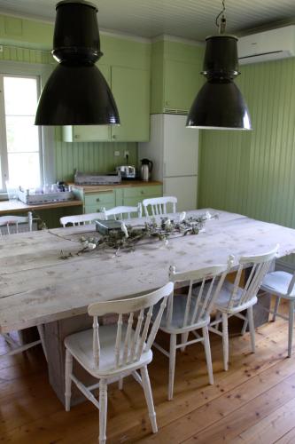 a kitchen with a large wooden table and chairs at Norrqvarn Hotel & Resort by Vänerport in Lyrestad
