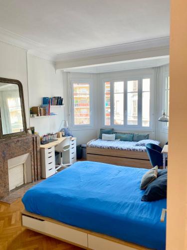 une chambre avec deux lits et un miroir dans l'établissement Villa Arson grand Appartement Art Deco, à Nice