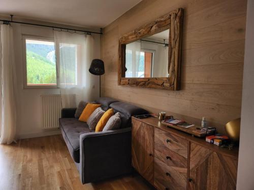 un salon avec un canapé et un miroir dans l'établissement AURON Appartement 2 pièces vue panoramique, à Saint-Étienne-de-Tinée