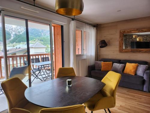 un salon avec une table, des chaises et un canapé dans l'établissement AURON Appartement 2 pièces vue panoramique, à Saint-Étienne-de-Tinée