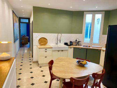 - une cuisine avec une table, une table et des chaises dans l'établissement Villa Arson grand Appartement Art Deco, à Nice