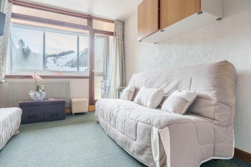 un salon avec un canapé et une fenêtre dans l'établissement Belle Hutte - La Bresse montagne et parking privé, à La Bresse