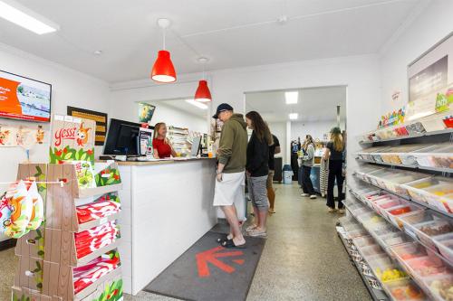 a group of people standing at a counter in a store at First Camp Bøsøre Strand Feriepark in Hesselager
