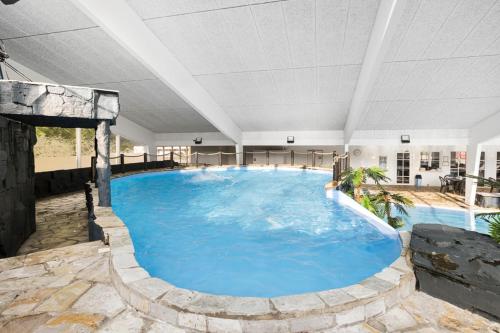 a large blue pool in a large room with a ceiling at First Camp Bøsøre Strand Feriepark in Hesselager