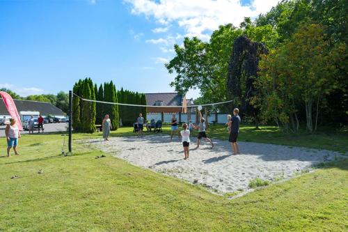 a group of people playing a game of volleyball at First Camp Bøsøre Strand Feriepark in Hesselager