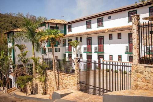a fence in front of a white building at Hotel Pousada Getsemani in Mariana