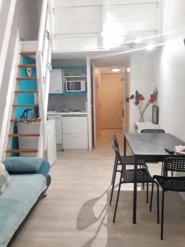 Cette chambre dispose d'une table à manger et d'une mezzanine. dans l'établissement Charmant appartement avec loggia à Saint-Hilaire-de-Riez - 18 m², à Saint-Hilaire-de-Riez