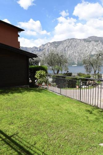 a fence in a yard with a view of a mountain at Camping Alpino - Nature Village in Malcesine