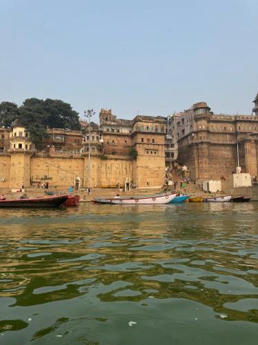 a group of boats in the water in front of a building at Rana Mahal - a Boutique Place in Varanasi