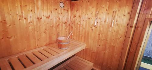 a small wooden sauna with a drink in it at Rigófészek Apartmanház in Gárdony