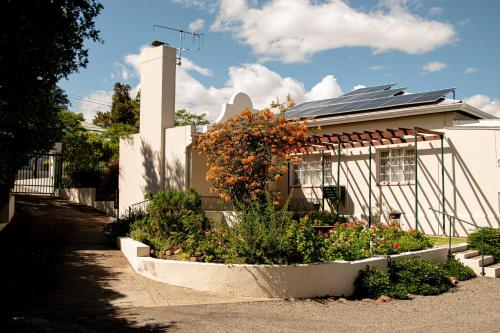 a house with a flower garden in front of it at 4 Rothman Street B&B in Graaff-Reinet