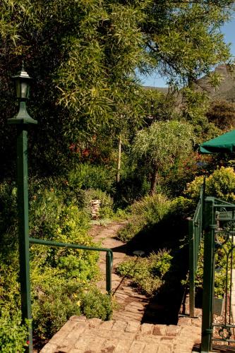 a green lamp post next to a brick path at 4 Rothman Street B&B in Graaff-Reinet