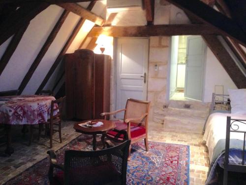 a bedroom with a bed and a table and chairs at Château d'Avanton in Avanton