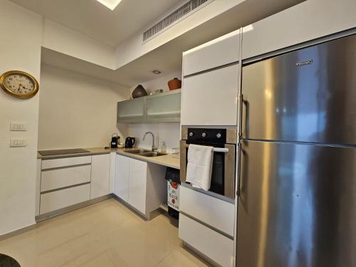 a kitchen with a stainless steel refrigerator at Savyon View Royal Suites - Alefimmoed in Jerusalem