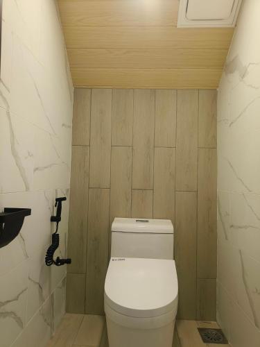 a bathroom with a white toilet in a room at The Pampines Villa, Mount Kinabalu in Ranau