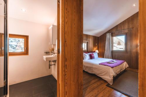 a bedroom with a bed and a sink in a room at Sonnmatten Boutique Hotel & Apartments Zermatt in Zermatt