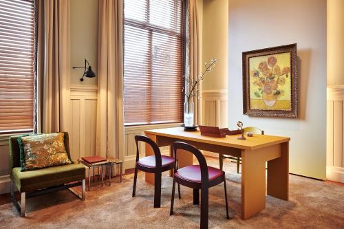 a desk and chairs in a room with a table and a chair at De L’Europe Amsterdam – The Leading Hotels of the World in Amsterdam