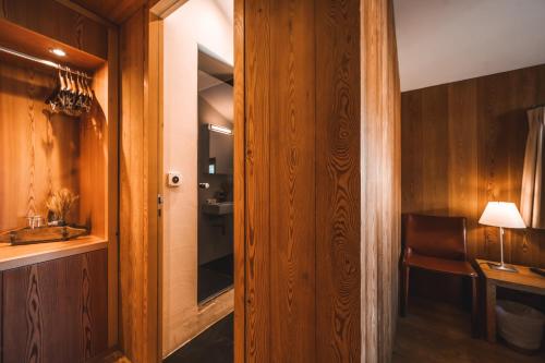 a room with a hallway with a chair and a mirror at Sonnmatten Boutique Hotel & Apartments Zermatt in Zermatt