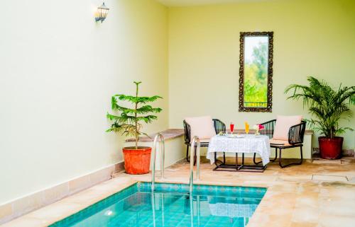 a patio with a table and a swimming pool at Guldaar Sariska - A luxury Forest Resort in Tehla