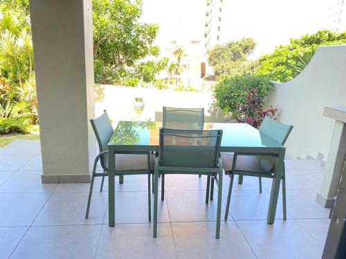 Una mesa de comedor y sillas en un patio. en 1 Kiahuna, en Durban
