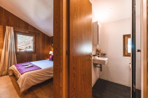 a bedroom with a bed and a sink in a room at Sonnmatten Boutique Hotel & Apartments Zermatt in Zermatt