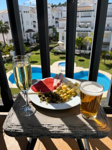 einen Teller mit Essen und ein Glas Wein auf dem Tisch in der Unterkunft Lägenhet högst upp, med pool och utsikt över havet in San Luis de Sabinillas