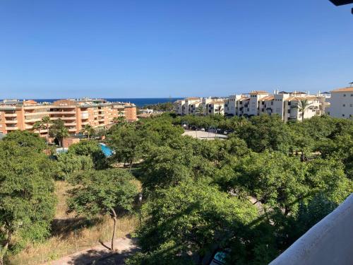 Blick auf eine Stadt mit Bäumen und Gebäuden in der Unterkunft Lägenhet högst upp, med pool och utsikt över havet in San Luis de Sabinillas